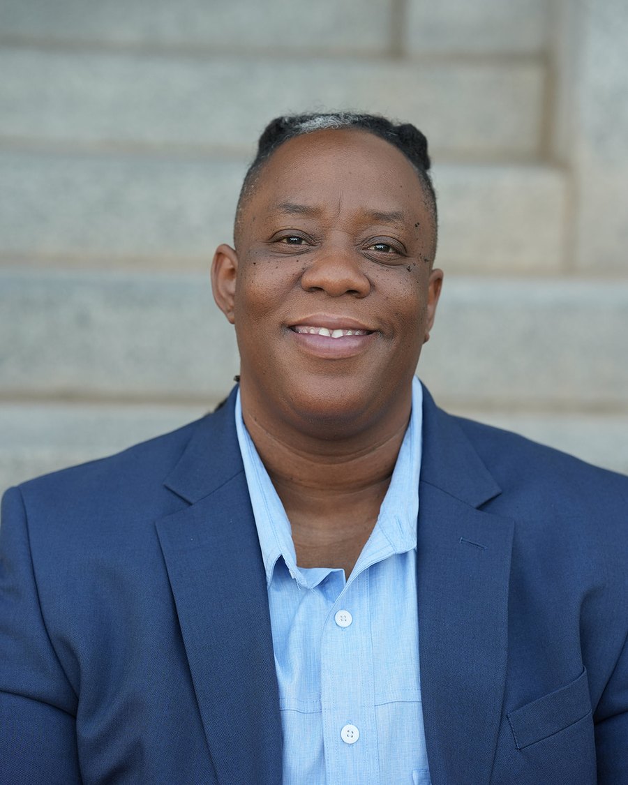 Portrait of Dana Johnson on the steps outside a public building.